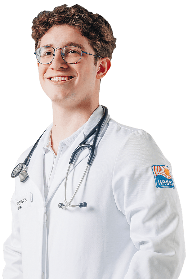 Estudante de Medicina UNI-RN sorrindo, vestindo jaleco branco e estetoscópio